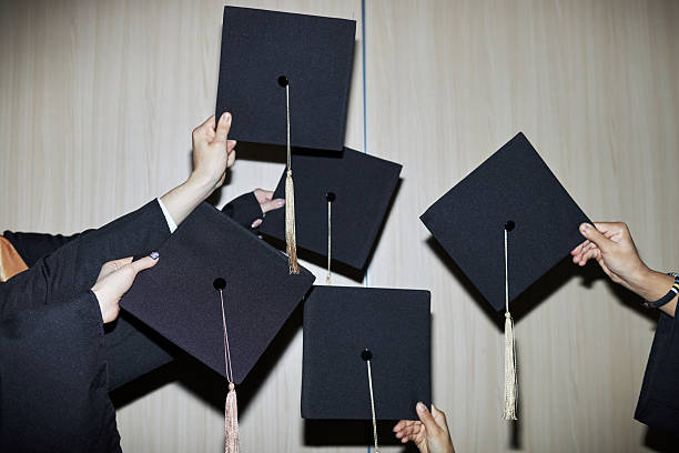 Three diverse young women celebrate their graduation milestone by taking a joyful selfie in their academic regalia.