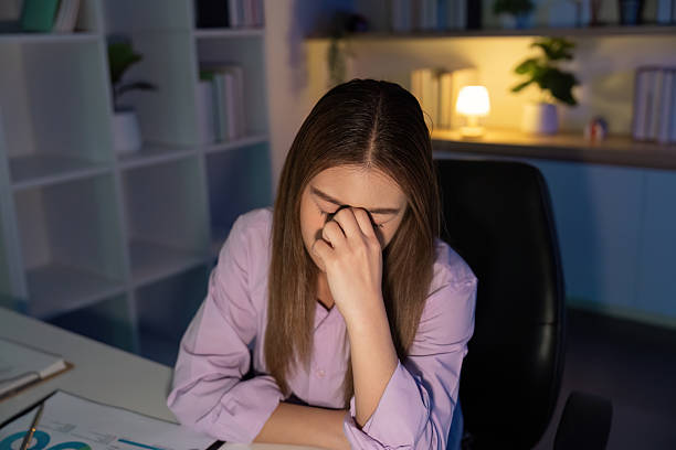istock Working Late. Overwhelmed woman resting her head on her hand while staring at the computer. 2222824993