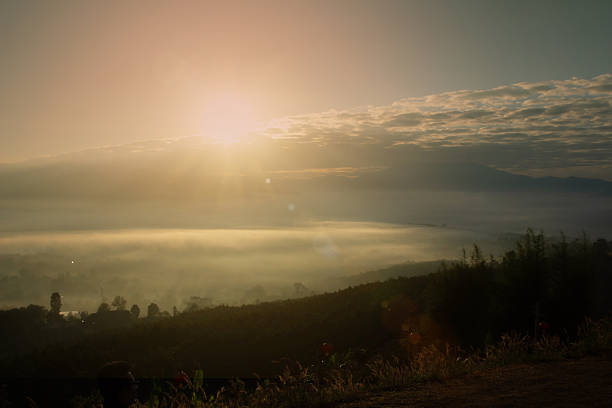 Abstract blurred orange sun sunrise background on mountain warm colors and bright sun light.sky sunny color orange light patterns plain abstract flare evening clouds blur.