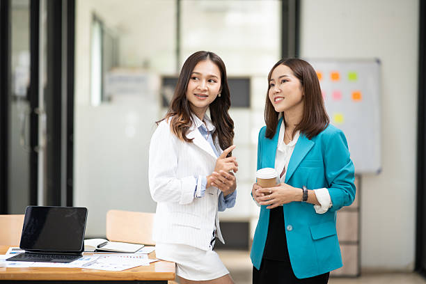 istock Two Asian businesswomen stand and talk about work. 2222831573