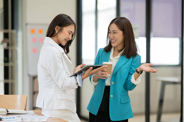 istock Two Asian businesswomen stand and talk about work. 2222831582