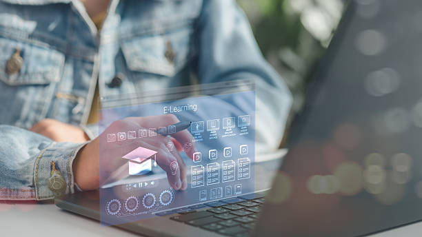 istock Person using laptop with futuristic E-learning interface, showing online lessons, audiobooks, and certifications, symbolizing digital education, remote learning, and smart training systems. 2222832498