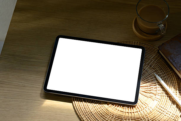 istock Minimalist workspace scene with digital tablet, coffee cup, and natural warm light 2222840057