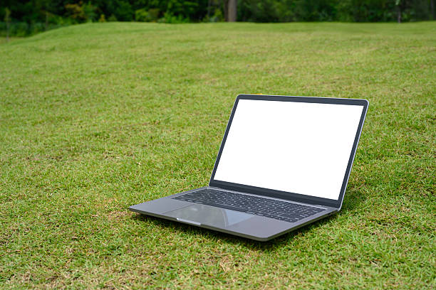 istock Laptop with blank screen placed on on fresh grass field. Technology lifestyle concepts 2222840092