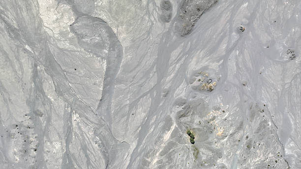 istock Intricate patterns of ash and erosion create a mesmerizing abstract view near crater Bromo, where subtle hints of vegetation and scattered structures emerge from the silvery volcanic plain 2222850423