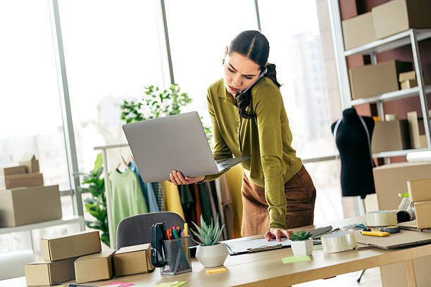 istock Busy designer working on laptop in her modern atelier, organizing tasks and managing her online fashion business 2222851259