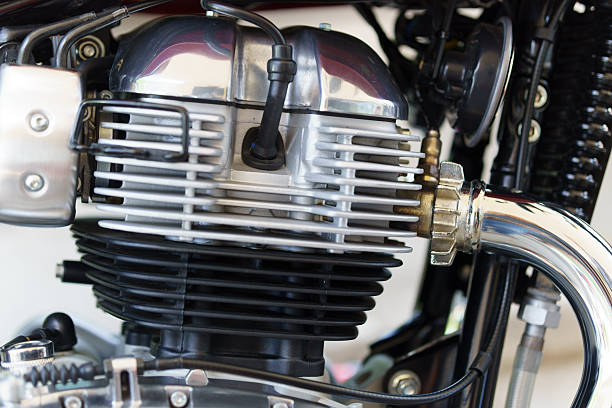 Classic air-cooled motorcycle engine close-up with visible fins and chrome pipe
