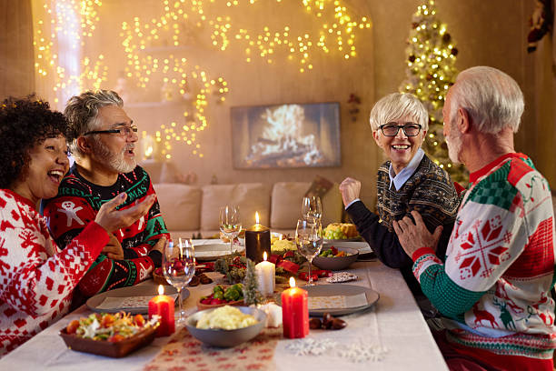 istock Happy senior couples talking on Christmas lunch in dining room. 2222853609