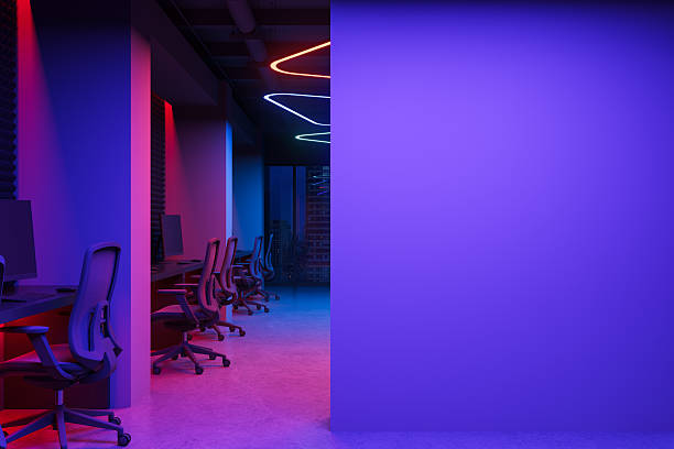 istock Futuristic office interior with gaming chairs, neon lights, and purple lighting creating a modern digital workspace environment at night. 3D Rendering 2222855574