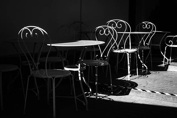 istock Vintage Wrought Iron Bistro Table and Chairs in Dramatic Shadow 2222855811