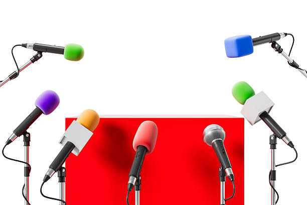 istock Colorful microphones arranged around a red podium on white background representing media conference concept. 3D Rendering. 3D Rendering 2222855824