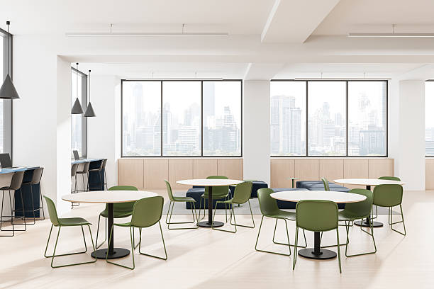 istock Modern office interior design with green chairs and round tables in a bright open space overlooking city skyline through large windows. 3D Rendering. 3D Rendering 2222855831