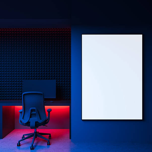 istock Empty framed poster mockup on blue wall beside modern workstation with red lighting and acoustic foam paneling in dark interior room. 3D Rendering 2222856017