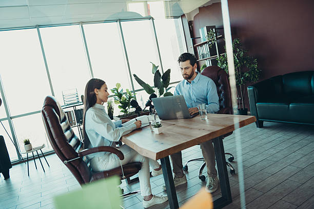 istock Two focused professionals collaborating in a modern office environment promoting teamwork and productivity as they discuss work ideas 2222859550