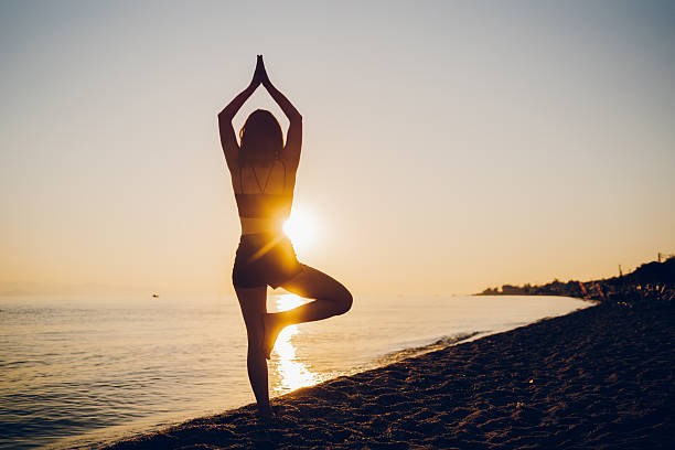 A young woman running on the beach. She enjoy exercising on the sea in sunset.