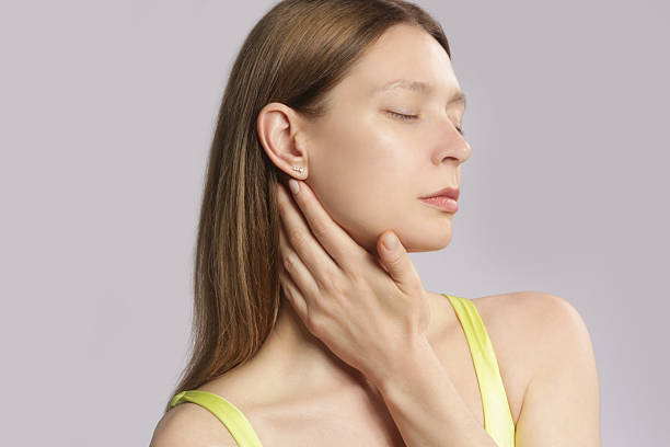 istock Caucasian woman touching her throat. Sore throat, cold, flu, tonsillitis or thyroid gland problem 2222860528
