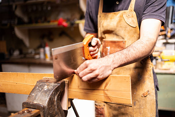 istock Carpenter using handsaw to cut wood in a sustainable workshop setting 2222864365