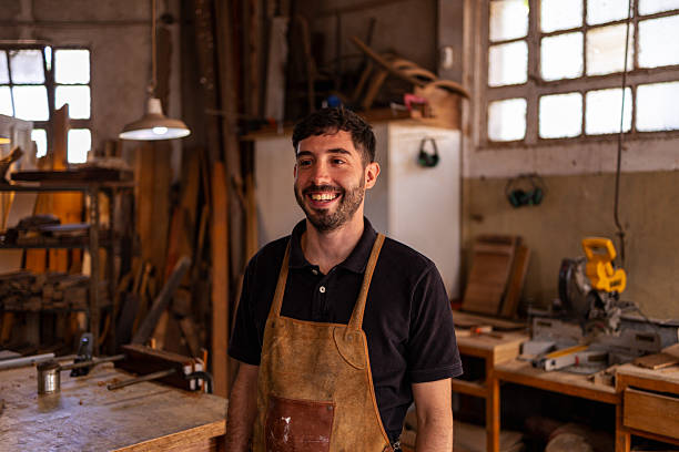 istock Smiling Carpenter in a Rustic Workshop Surrounded by Tools and Wooden Materials 2222864424