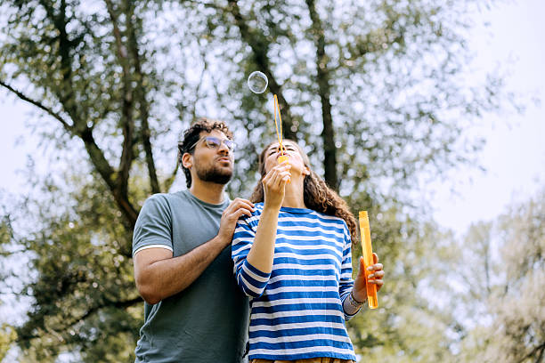 istock Young couple blowing soap bubbles outdoors 2222867466