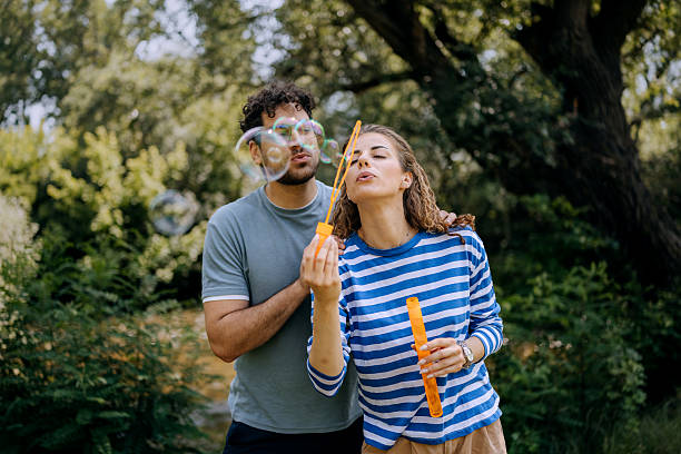 istock Young couple blowing soap bubbles outdoors 2222867470