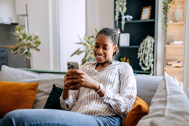 istock Beautiful young woman relaxing at home and using her smartphone 2222869310
