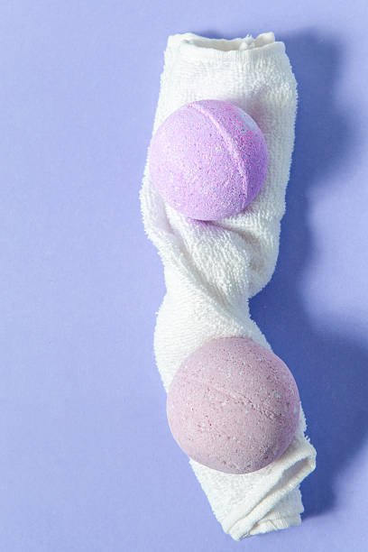 Bath bombs wrapped in a white towel on a purple background creating a calming ambiance