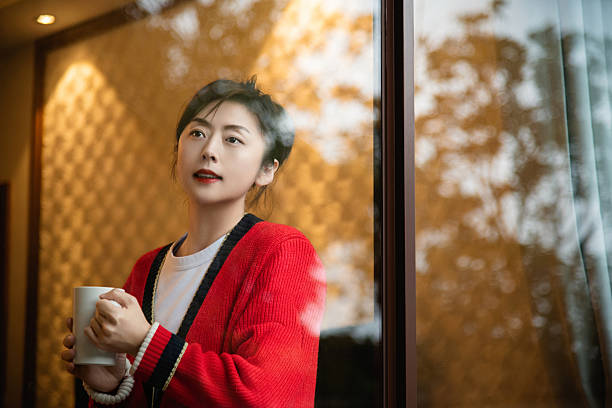 Women drinking a cup of coffee behind window