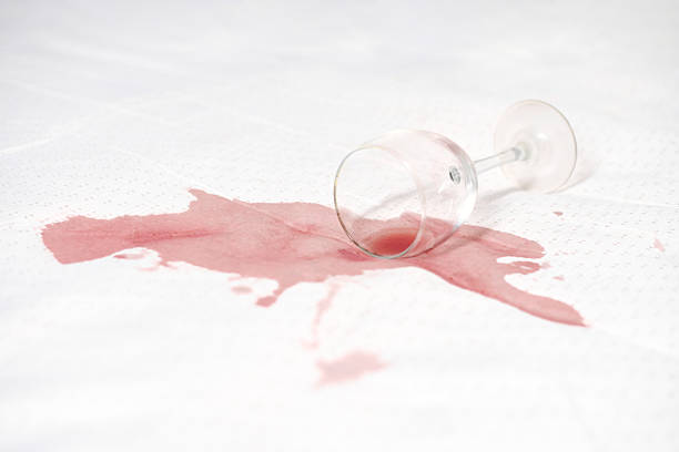 Red wine poured into crystal glass. Wine bottle in hand. Copy space.
