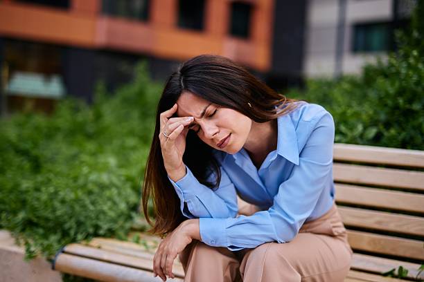 istock Stressed Woman Sitting on Bench Outdoors in Urban Setting 2222874893