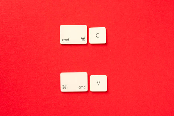 istock White keyboard keys arranged to show CMD+C and CMD+V copy-paste shortcuts on vibrant red background. Useful for tech or productivity concepts. 2222874944