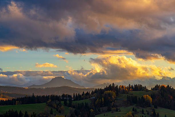 Scenic landscape with dramatic cloudscape over Mala Fatra mountain range during colorful autumn sunset in Terchova, Slovakia