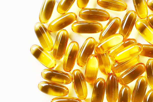 istock Golden fish oil capsules on white background. 2222876748
