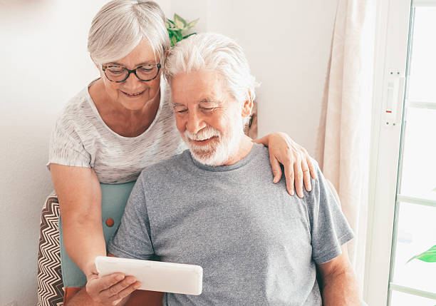 istock Video call concept. Bonding loving senior retired couple using digital tablet for online communication via video meeting, smiling white-haired man and woman looking and talking 2222877477