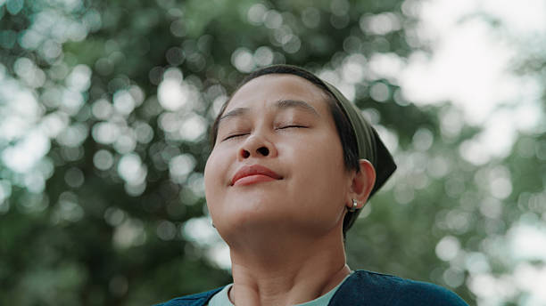 istock Asian woman taking a deep breath in public park 2222878476