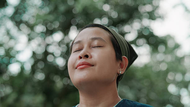 istock Asian woman taking a deep breath in public park 2222878783