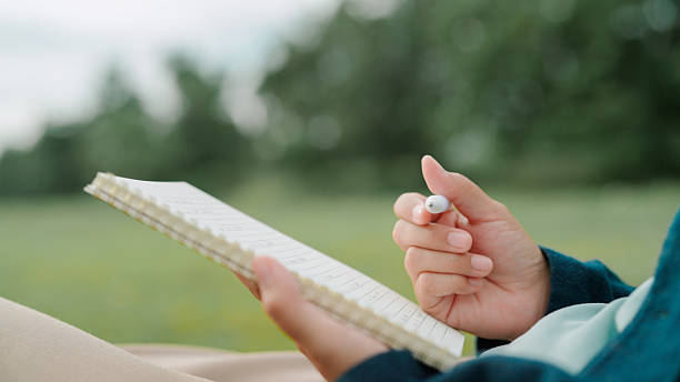Asian woman writing on notebook in public park