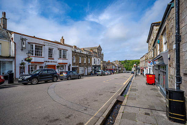 Helston, UK. 25 June 2025. Mix of shops in town of Helston in Cornwall