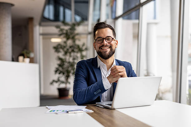 istock Smiling businessman working on laptop in modern office 2222881967