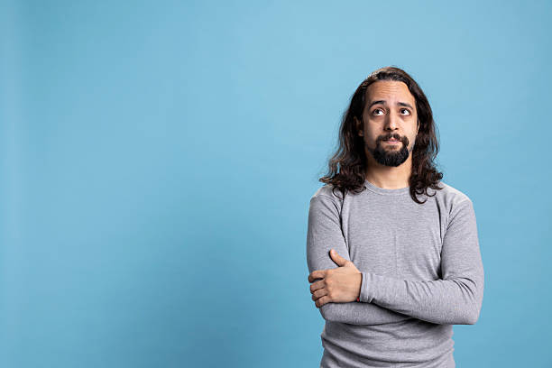 istock Contemplative young adult trying to find a solution against blue background 2222883906