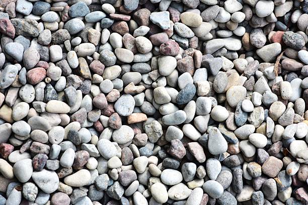istock Close-up view of small pebbles creating a natural pattern and texture. Tiny gravel stones in various earthy tones form a seamless background, ideal for use in design or nature-themed projects. 2222888565