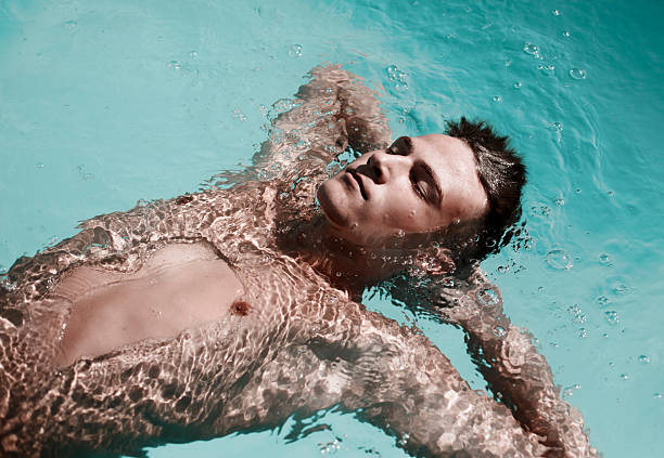 A person enjoying a tranquil moment floating on the surface of a pristine swimming pool.