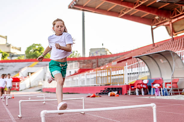 istock Young Girl Jumping Over Hurdles During a Track and Field Practice 2222891717
