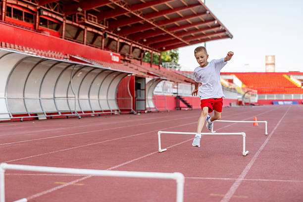 istock Young Athlete Jumping Over Hurdles at Track and Field Stadium 2222891738