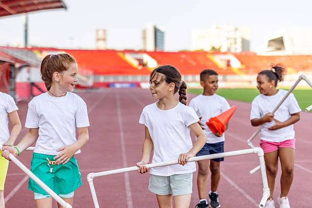 Young kids enjoy teamwork during an engaging activity in a vibrant outdoor sports stadium. Their cooperation and energy embody fun, unity, and active participation in a structured group setting.