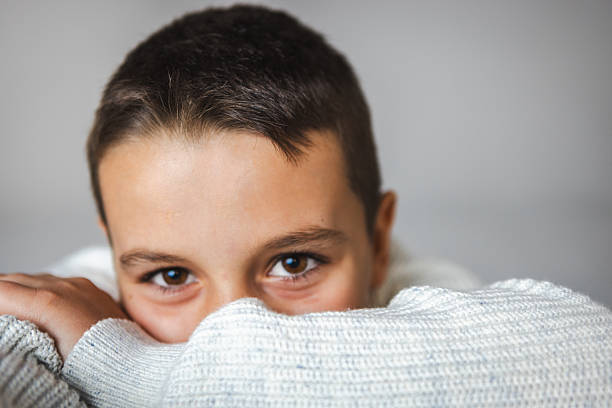 Portrait of a young boy resting on a soft surface, displaying a cheerful mood and calm expression, ideal for representing childhood, joy, and serenity.
