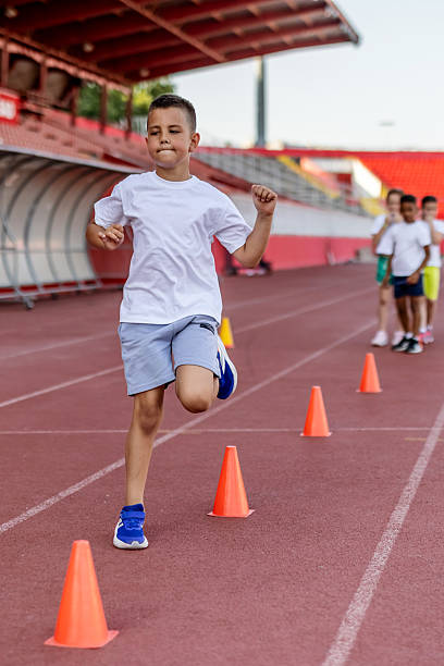 istock Young Boy Running Through Orange Cones During Athletic Training Outdoors 2222891919