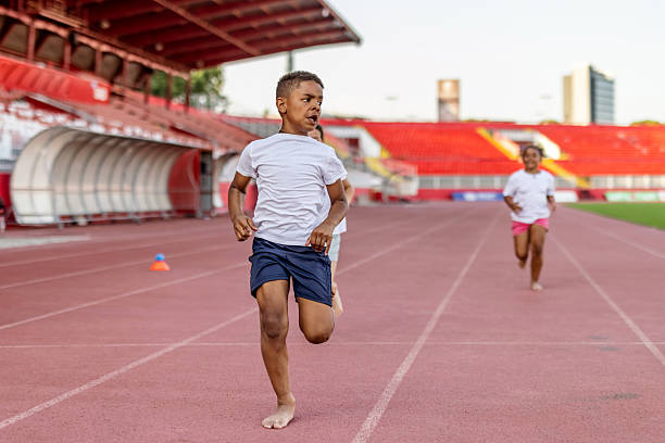 istock Children Running Barefoot on Track During a Bright Sunny Day 2222892007