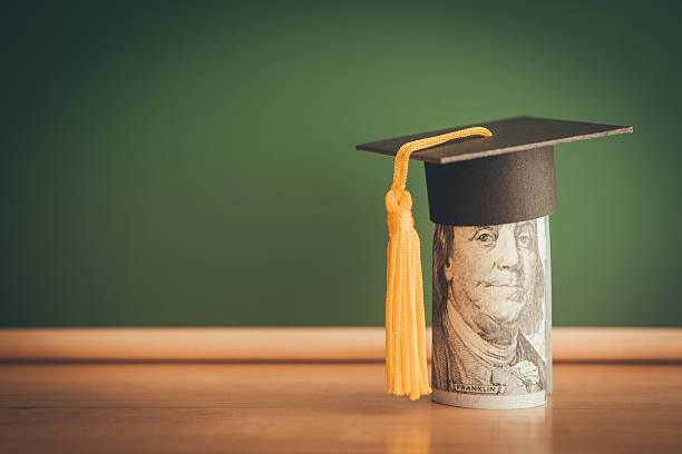 istock US dollars banknote wears graduation cap chalkboard background in classroom. 2222893758