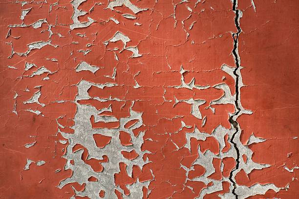 Close Up of Cracked and Peeling Red Paint on a Textured Surface