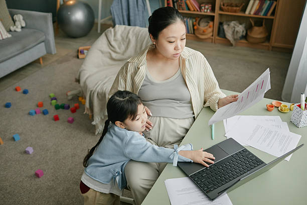 istock Pregnant Asian Woman Spending Time with Daughter While Working from Home 2222899213
